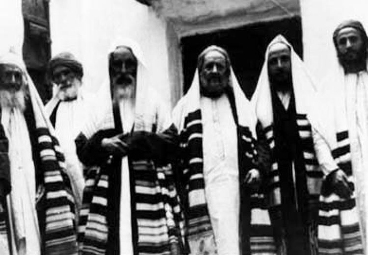 הנוהגים לצאת בשבת עטופים בטלית לבית הכנסת ולביתם – היש בנוהג זה חשש ליוהרה?